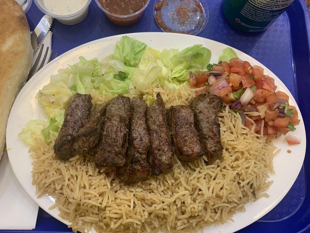 barg kabob on rice with some lettuce and chopped tomatoes